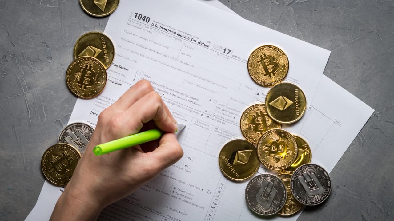 Das Bild zeigt eine Hand, welche die Bitcoin Mining Steuern in ein Steuerformular einträgt.