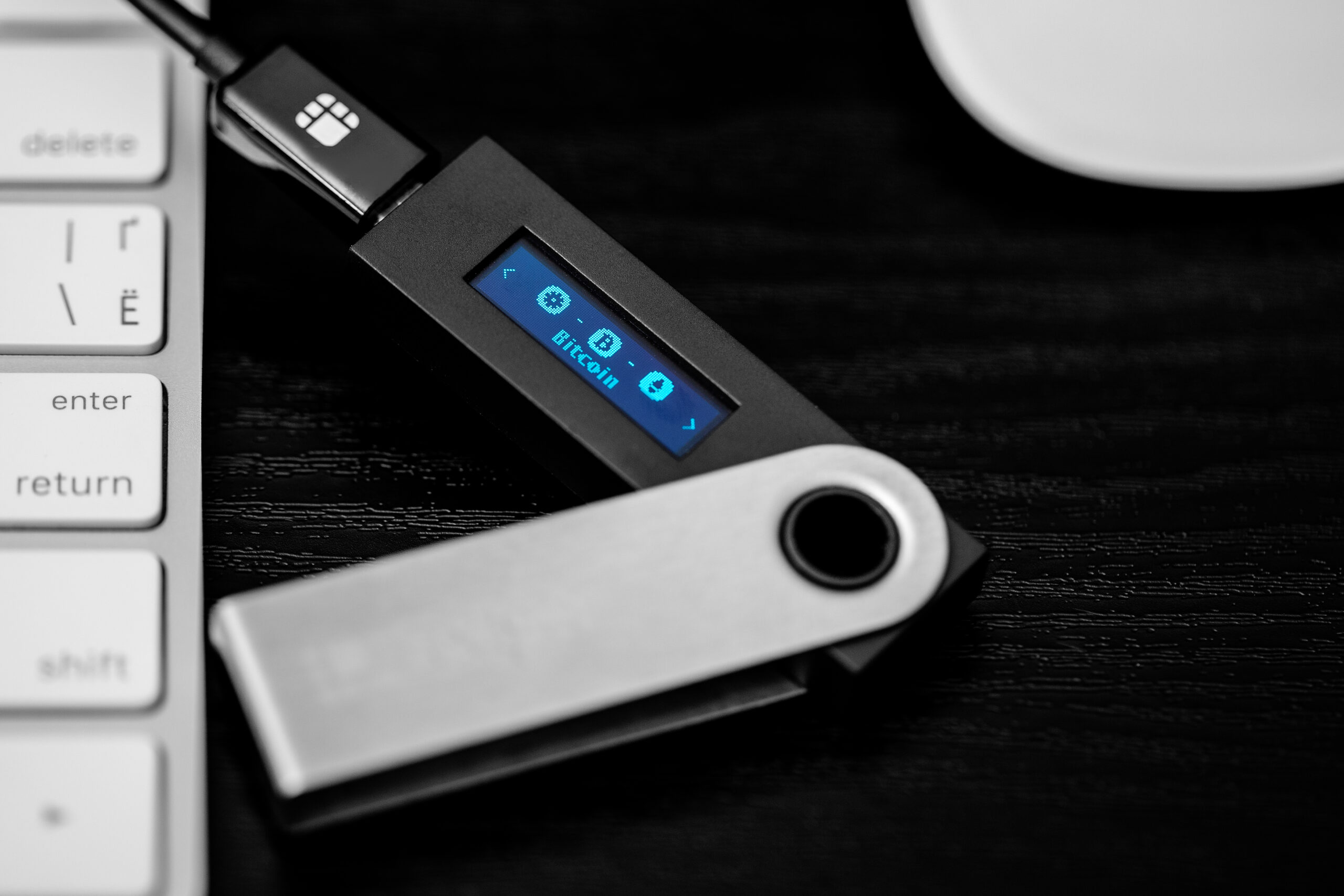 Das Bild zeigt die Einrichtung des Ledger Nano S Plus per USB-Kabel an einem Computer.