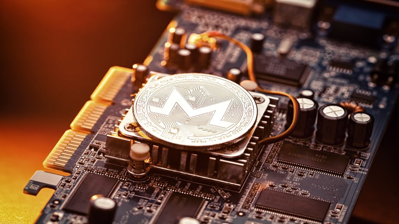 Das Bild zeigt eine Platine mit einem Monero-Coin auf dem Prozessor als Symbol für das Monero-Mining