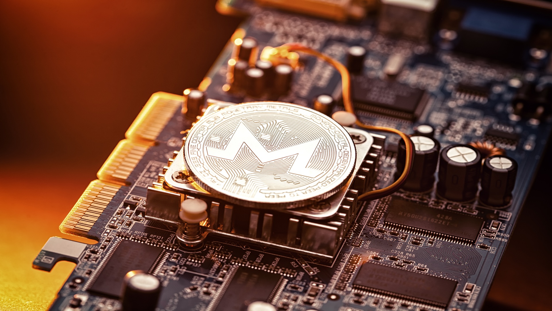 Das Bild zeigt eine Platine mit einem Monero-Coin auf dem Prozessor als Symbol für das Monero-Mining