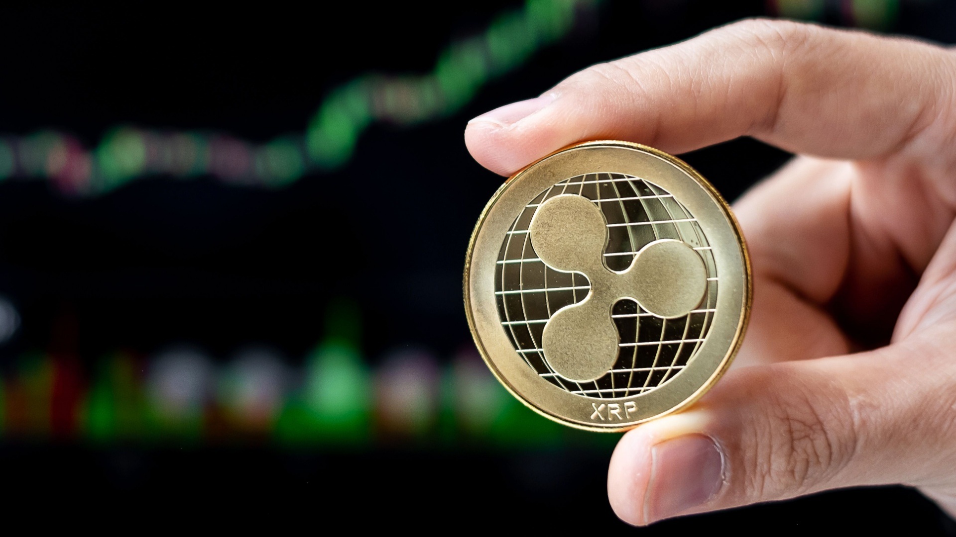 Eine Hand hält eine Münze mit XRP-Logo als Symbol für das Staking