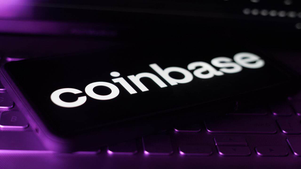 Coinbase Logo auf Smartphone mit violettem Hintergrund – Symbolbild für Coinbase Staking