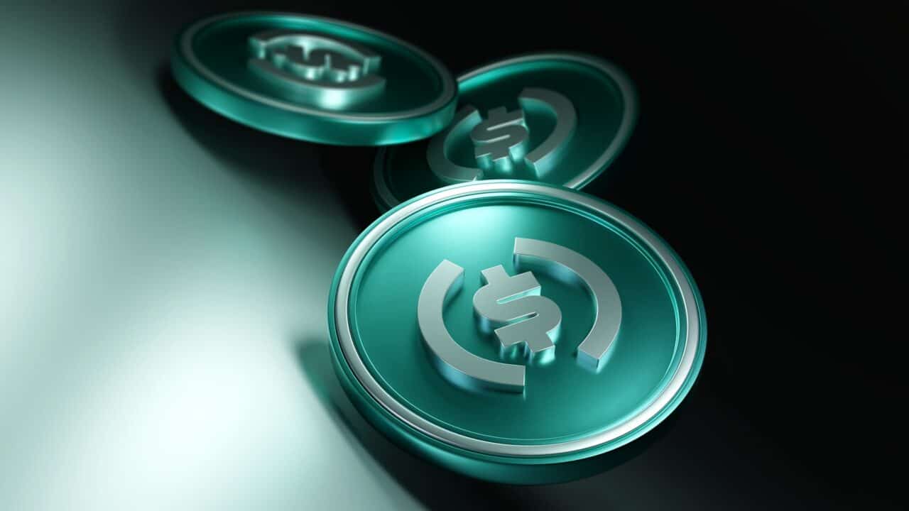 Das Bild zeigt drei grünlich leuchtende Münzen mit USDC-Logo als Symbol für das Staking.