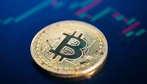 Eine Bitcoin-Münze vor einem Charthintergrund