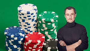 Mehrere bunte Pokerchips sind vor einem grünen Hintergrund in Stapel aufgeteilt. Rechts auf dem Bild steht ein Mann mit schwarzem Rollkragenpullover.