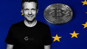 Schwarz-weißes Porträt eines lächelnden Mannes vor einem blauen Hintergrund mit gelben Europasternen; neben ihm liegt eine graue Bitcoin-Münze auf der Flagge der Europa-Union.