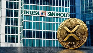Eine XRP-Münze neben einem Bürogebäude der Intesa Sanpaolo.