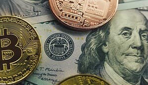 Im Hintergrund befinden sich US-Dollar-Banknoten. Im Vordergrund sind wiederum zwei Münzen abgebildet, die Bitcoin und eine andere Kryptowährung darstellen sollen.