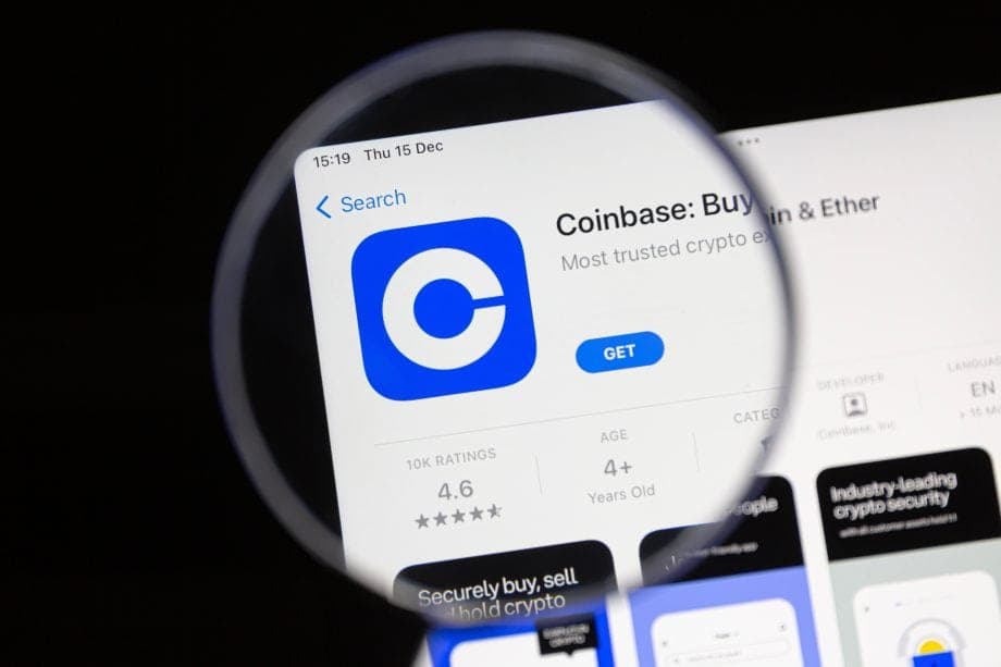 Coinbase-App auf einem Smartphone-Bildschirm unter einer Lupe. Symbolbild für die Kryptobörse Coinbase und den Handel mit digitalen Vermögenswerten.