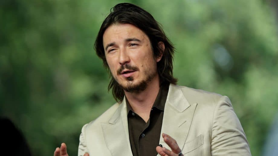 Der Robinhood CEO Vlad Tenev gestikuliert in einem beigen Anzug