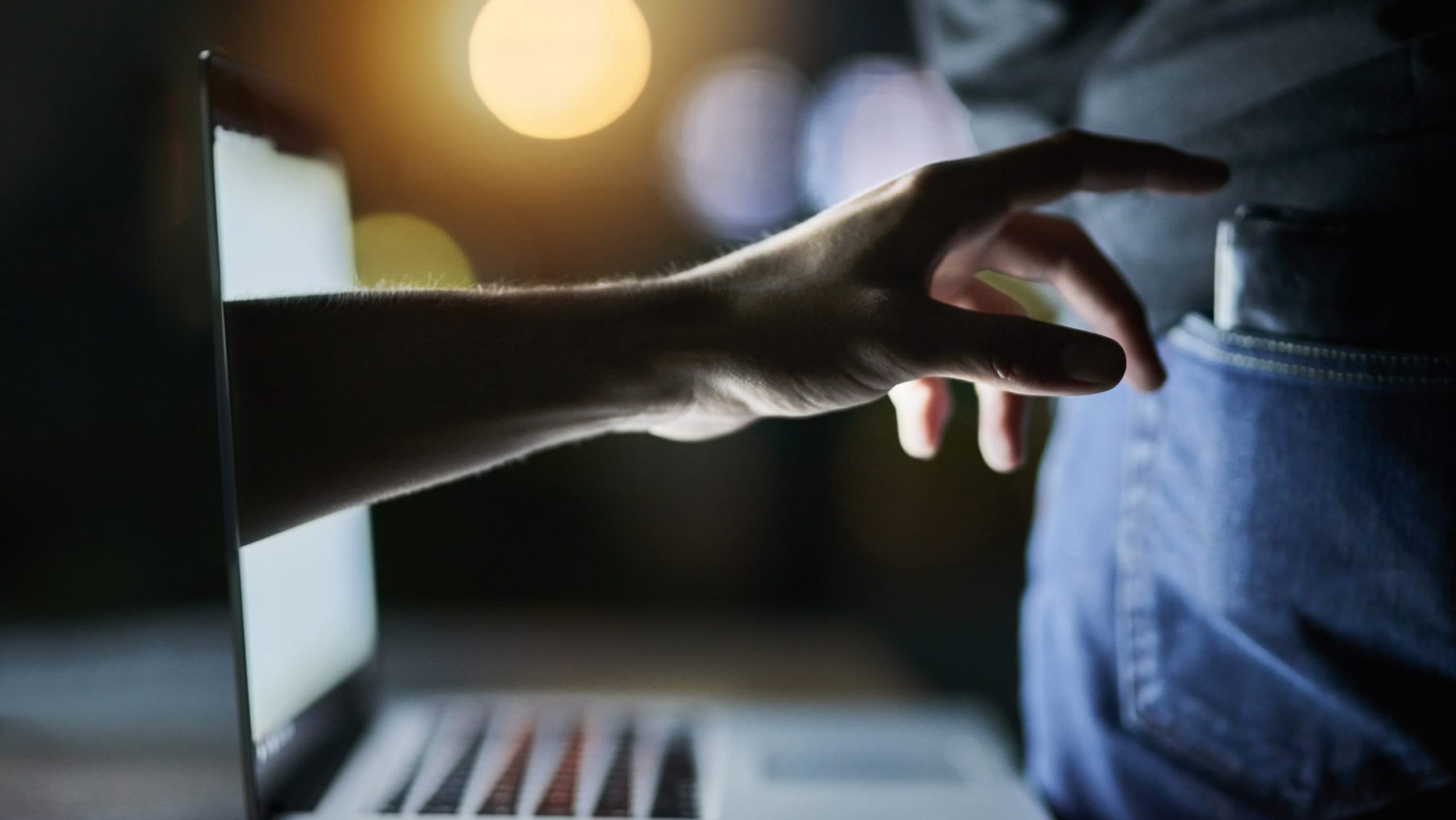 Das Bild zeigt eine Hand, die nach einer Brieftasche greift