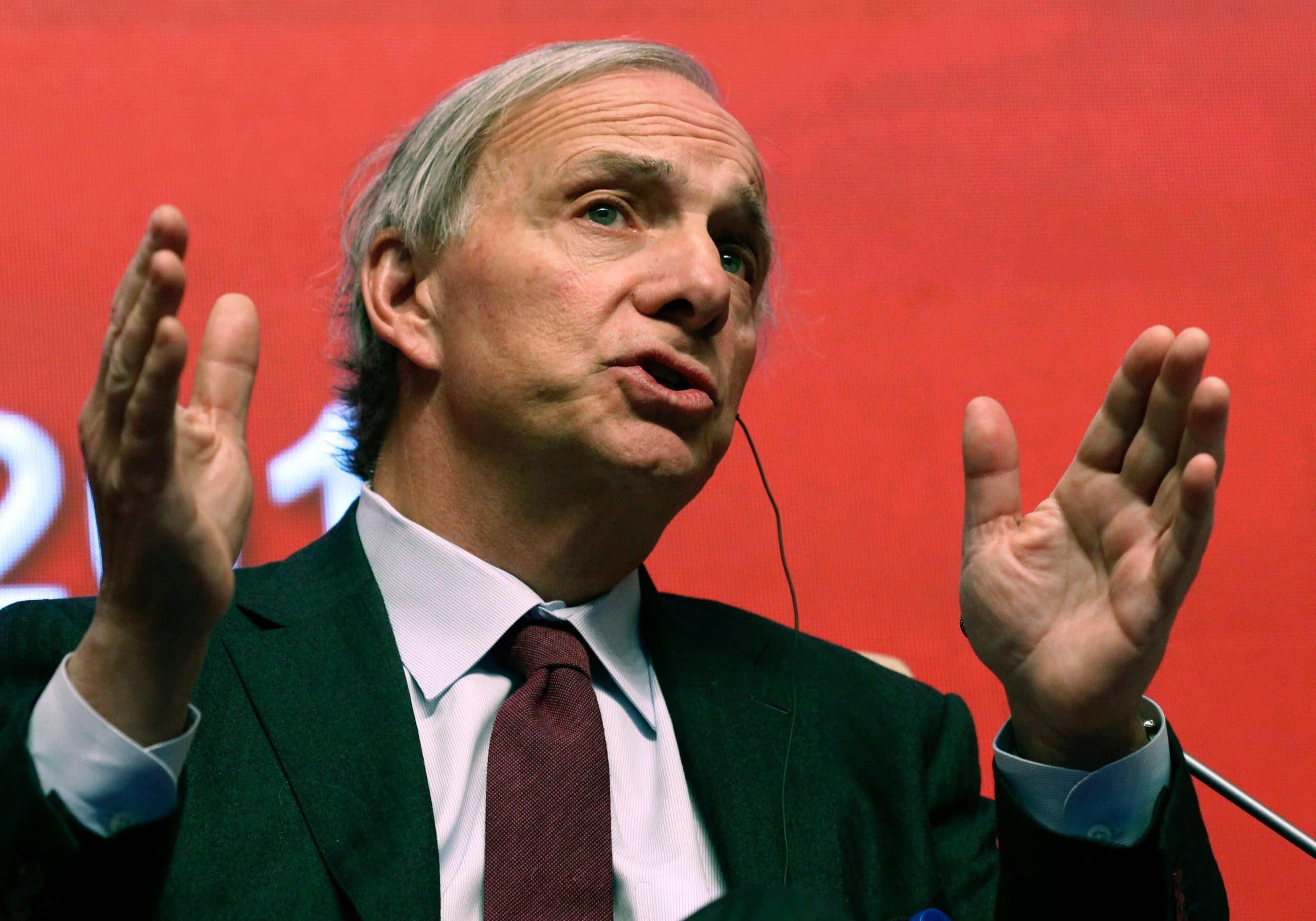 KI-Blase: Ray Dalio gestikuliert bei einem Auftritt vor rotem Hintergrund