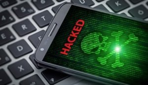 skull of death on smartphone screen. Hacked mobile phone on laptop computer