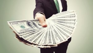 Business Man Displaying a Spread of Cash