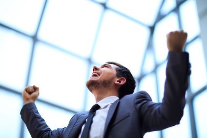 businessman with arms up celebrating his victory