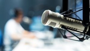 young man dj works in modern broadcast studio