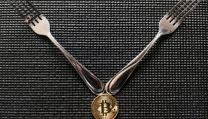 Zwei Gabeln auf einer Bitcoin Münze