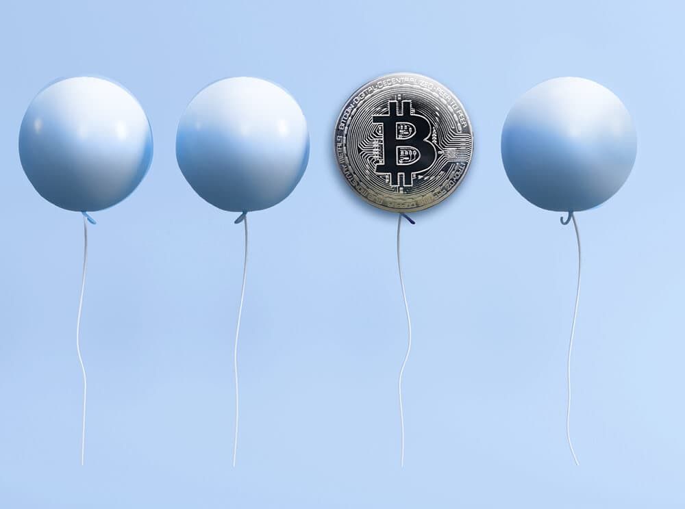 Vier Luftballons, der dritte von links mit einem Bitcoin-Symbol