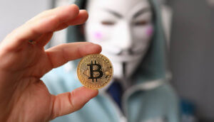 Symbollbild Binance-KYC-Leak: Mskierter Mann mit Bitcoin-Münze