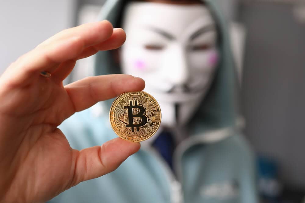 Symbollbild Binance-KYC-Leak: Mskierter Mann mit Bitcoin-Münze