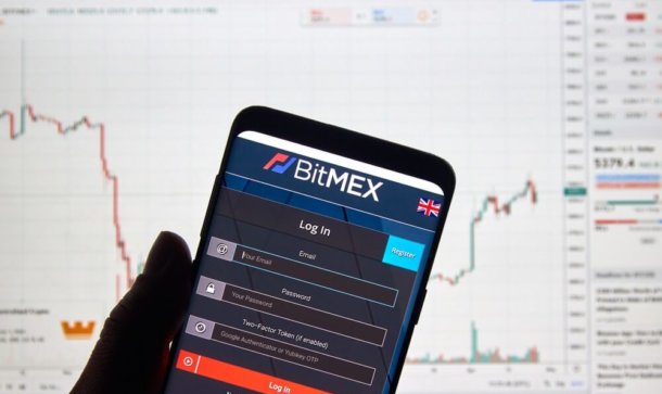 Bitcoin Trading: BitMEX startet neue ETH/USD Futures Smartphone mit App von BitMEX vor Desktop-Hintergrund mit Chart.