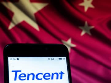 Smartphone mit Schriftzug Tencent vor chinesischer Flagge.