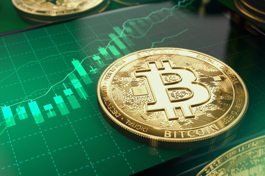 Bitcoin-Kurs (BTC) verzeichnet Gewinne – Hodler im Hamstermodus Bitcoin-Münze liegt auf einem Smartphone, das eine Chart mit grünen Kerzen abbildet.