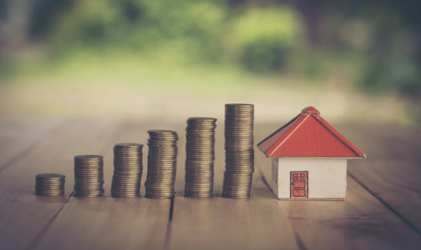 Frankreich zieht nach in der Immobilien-Tokenisierung Gestapelte Münzen und Miniaturhaus sollen Sparen verdeutlichen