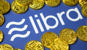 Libra-Münzen liegen auf einem blauen Hintergrund, der das Logo von Libra zeigt.