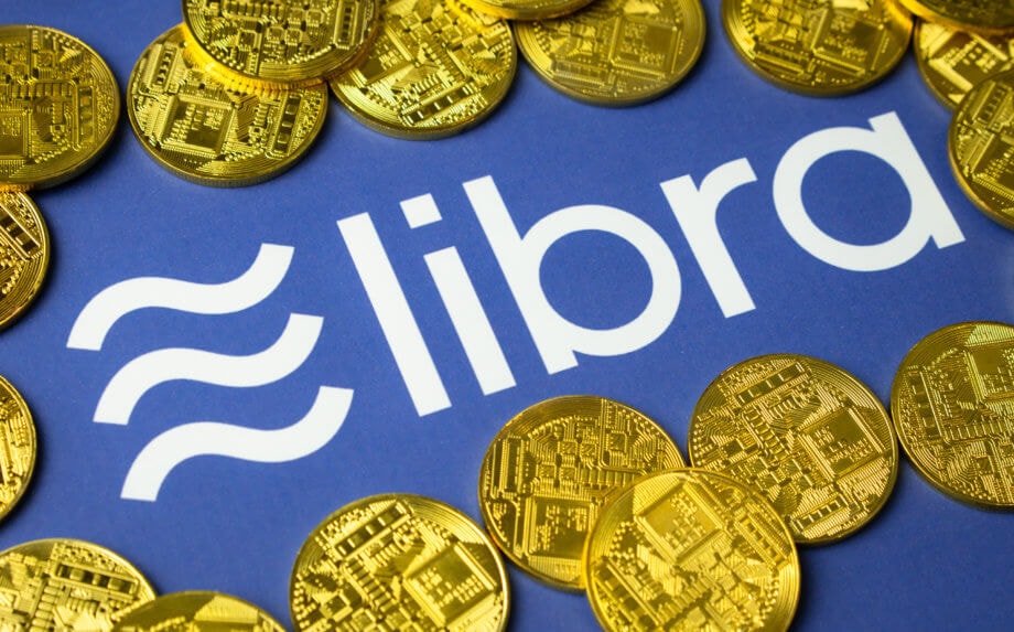 Libra könnte „die globale Zahlungsindustrie umgestalten“ Libra-Münzen liegen auf einem blauen Hintergrund, der das Logo von Libra zeigt.