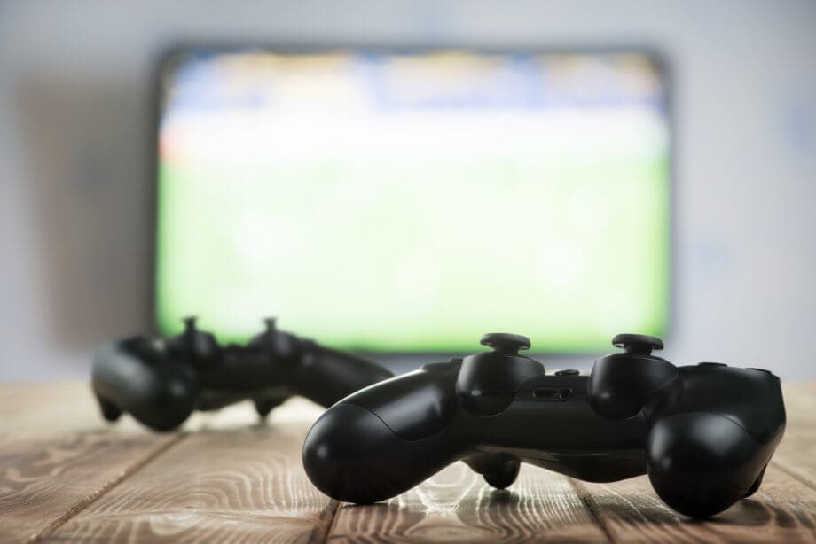Blockchain Gaming mit Telos: Qudo ermöglicht Kryptozahlungen für Unity Zwei Controller vor einem Bildschirm