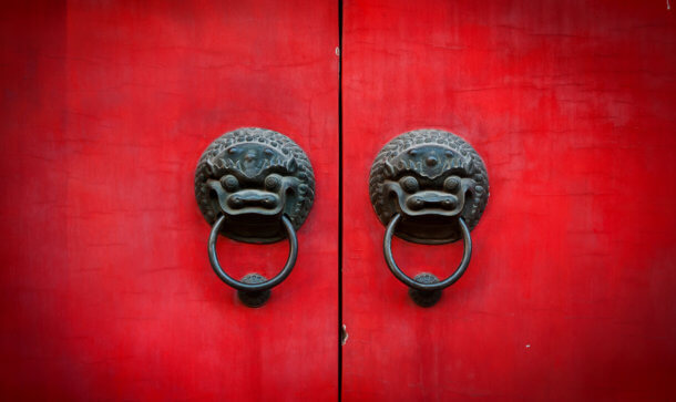 China bekommt bei digitalem Zentralbankgeld prominente Unterstützung rote tür mit zwei china drachen als türgriffe, an denen jeweils ein ring hängt. man sieht in der mitte der beiden türhälften einen schwarzen spalt