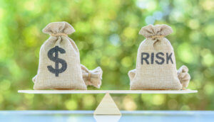 Balance zwischen Sack mit Dollarzeichen und Sack, auf dem Risk steht