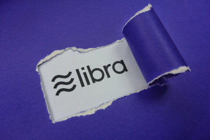 libra-symbol erscheint unter einem riss in einem blauen papier