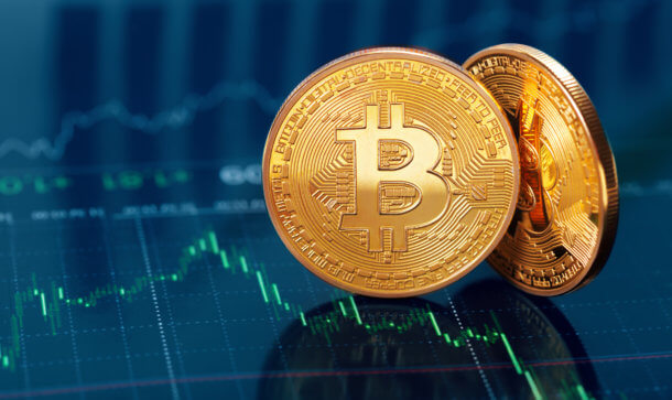 Zwei Goldene Bitcoin Münze auf Trendlinien im Hintergrund