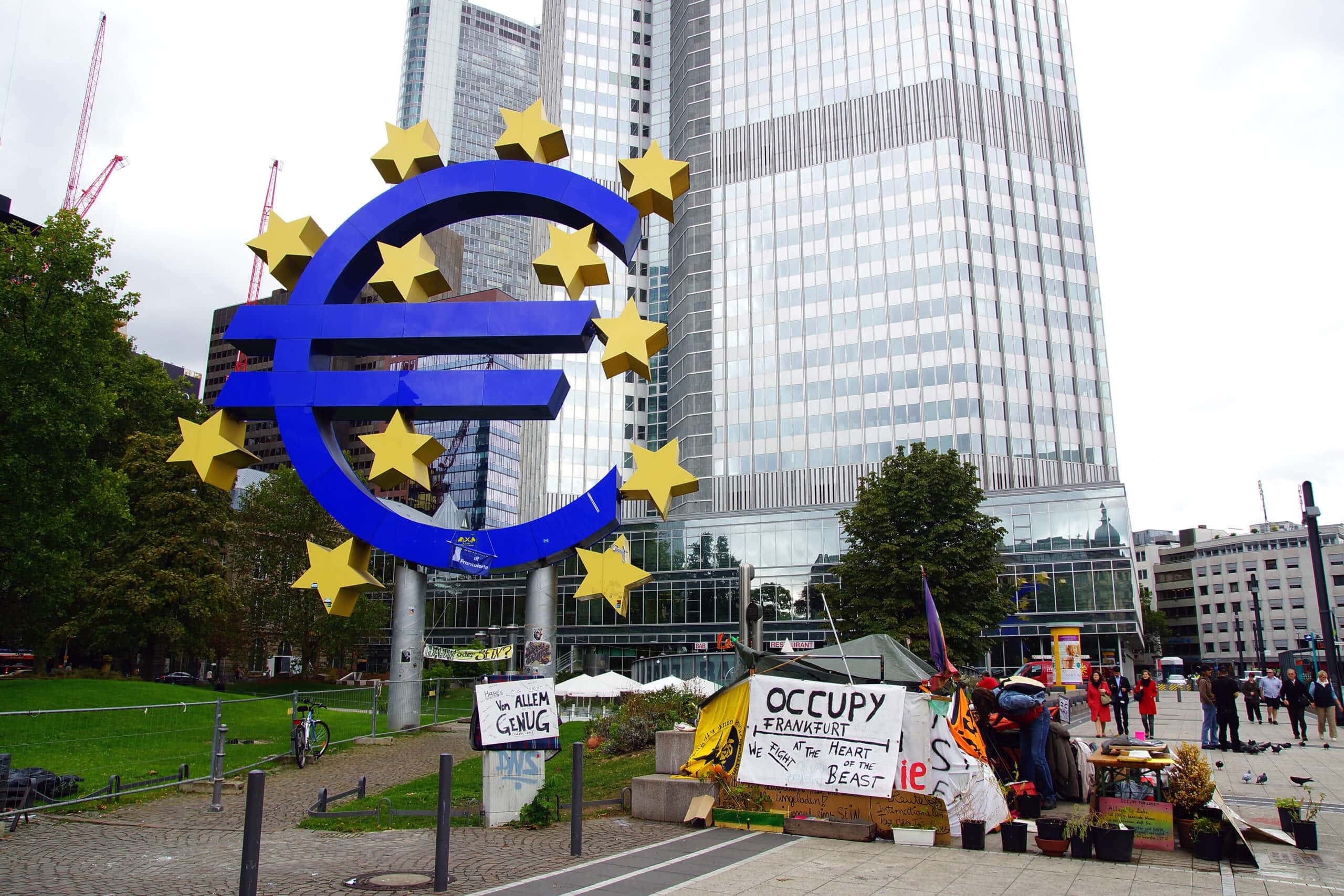 Eurozeichen im Vordergrund und im Hintergrund ein Frankfurter Bankgebäude