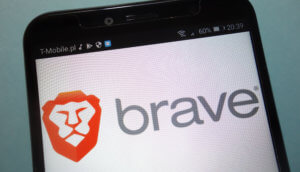 Ein Smartphone Display und im Hintergrund wird der Brave Browser angezeigt