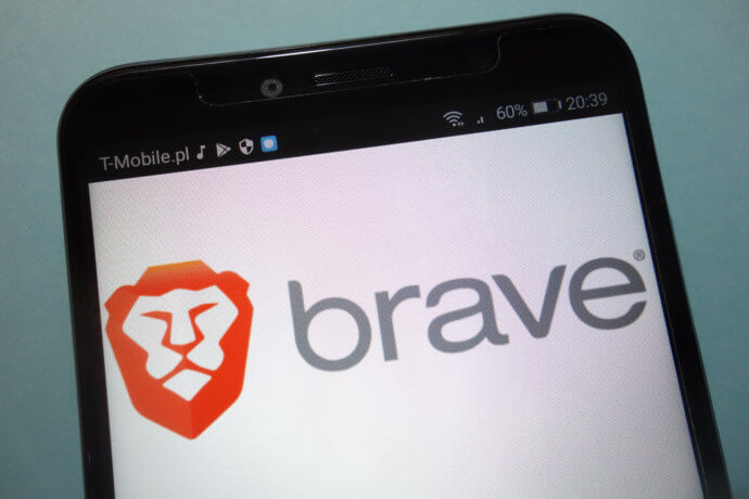 Ein Smartphone Display und im Hintergrund wird der Brave Browser angezeigt