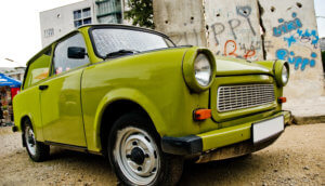 Grüner Trabant steht symbolisch für Digitaler Euro vor Graffiti Wand