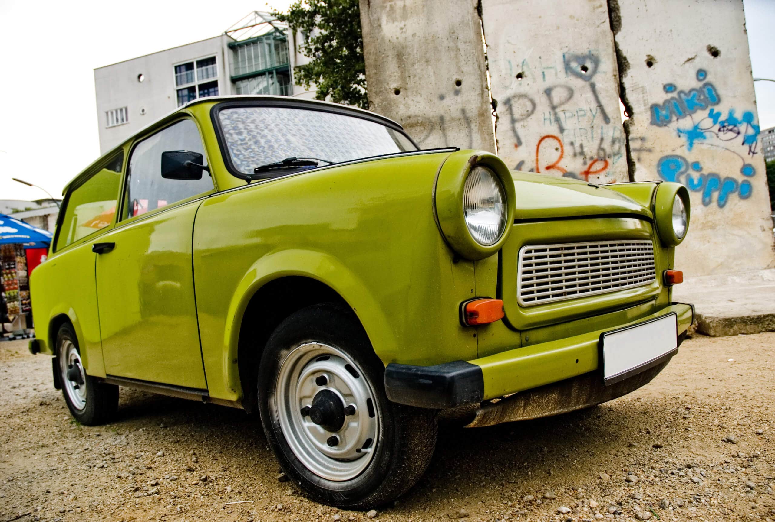 Grüner Trabant steht symbolisch für Digitaler Euro vor Graffiti Wand