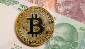 Goldene Bitcoin Münze liegt auf indischen Geldscheinen