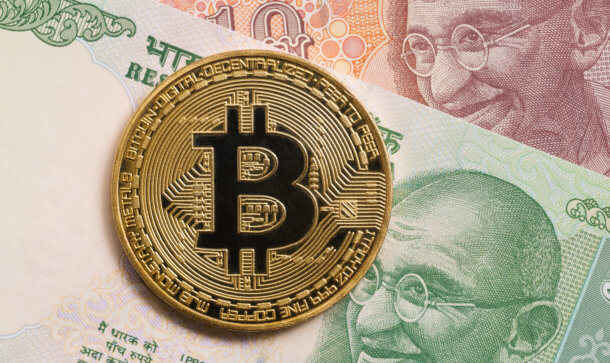 Schlafender Riese erwacht: Indien verzeichnet Krypto-Rekordzuwäche Goldene Bitcoin Münze liegt auf indischen Geldscheinen