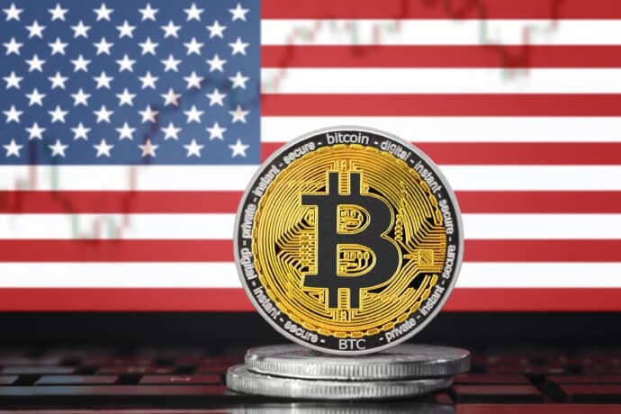 bitcoin münze vor amerikanischer flage