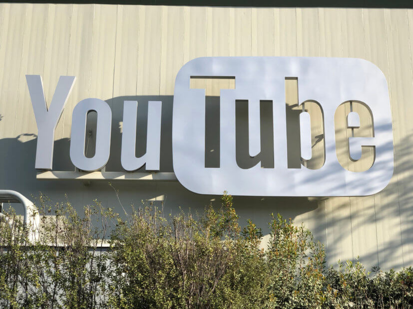 Scam-Alarm: Ripple-Geschäftsführer verklagt YouTube silbernes youtube symbol vor beigenem gebäude von der sonne geküsst von ripple verklagt