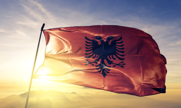 Albanien bringt Klarheit in Krypto-Regulierung Die Flagge von Albanien weht vor der Sonne