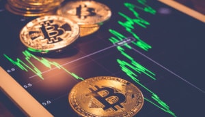 bitcoin münzen und der bitcoin-kurs auf einem tablett