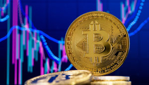 bitcoin-münze hinter liegenden bitcoin-münzen vor einer chart mit blauem hintergrund