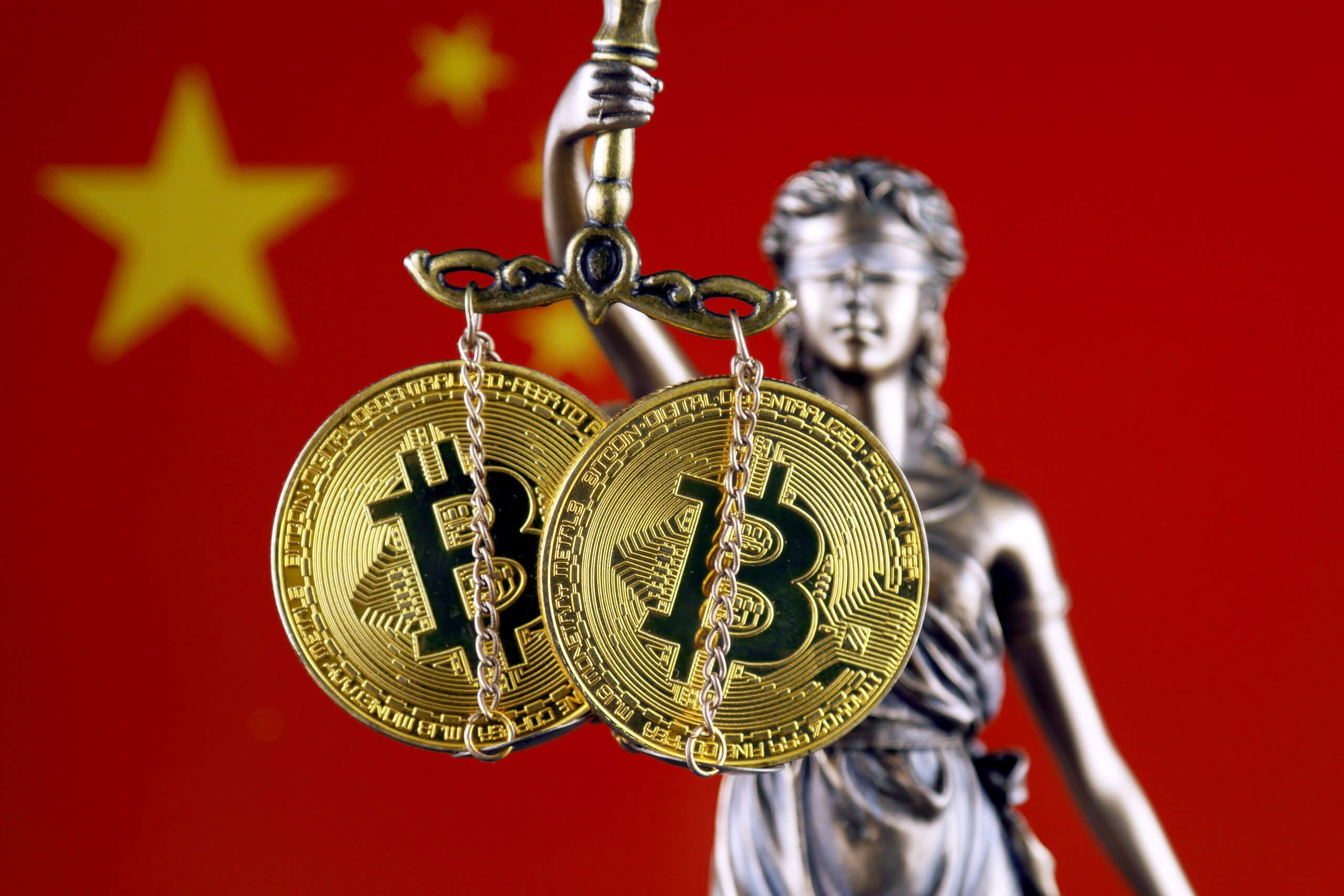 bild von justitia, die in ihrer Waage zwei Bitcoin Münzen hat. Im Hintergrund die Flagge von China