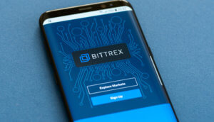 symbol der bitcoin-börse bittex auf einem smartphone mit login möglichkeit auf blauem hintergrund