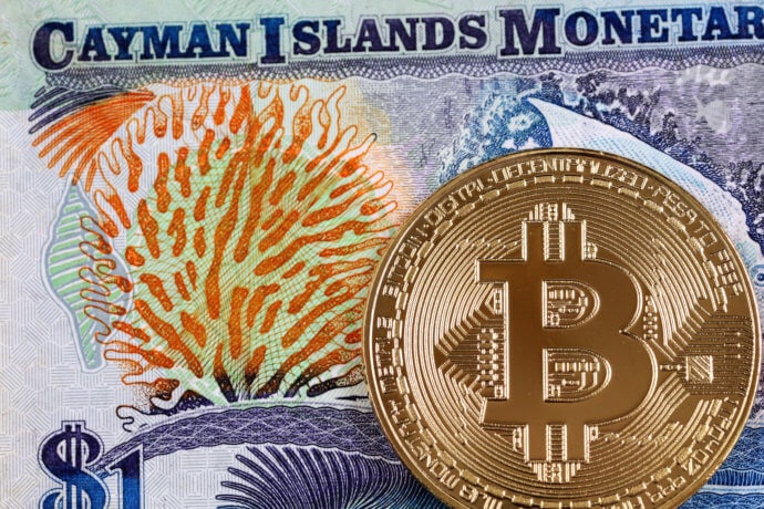 Nahaufnahme einer Banknote der Cayman Islands mit Gold-Bitcoin